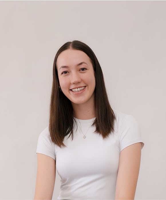 Female team member smiling, wearing a white top