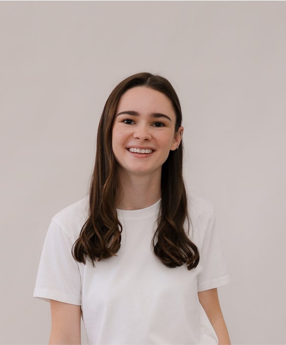 Female team member smiling, wearing a white t-shirt